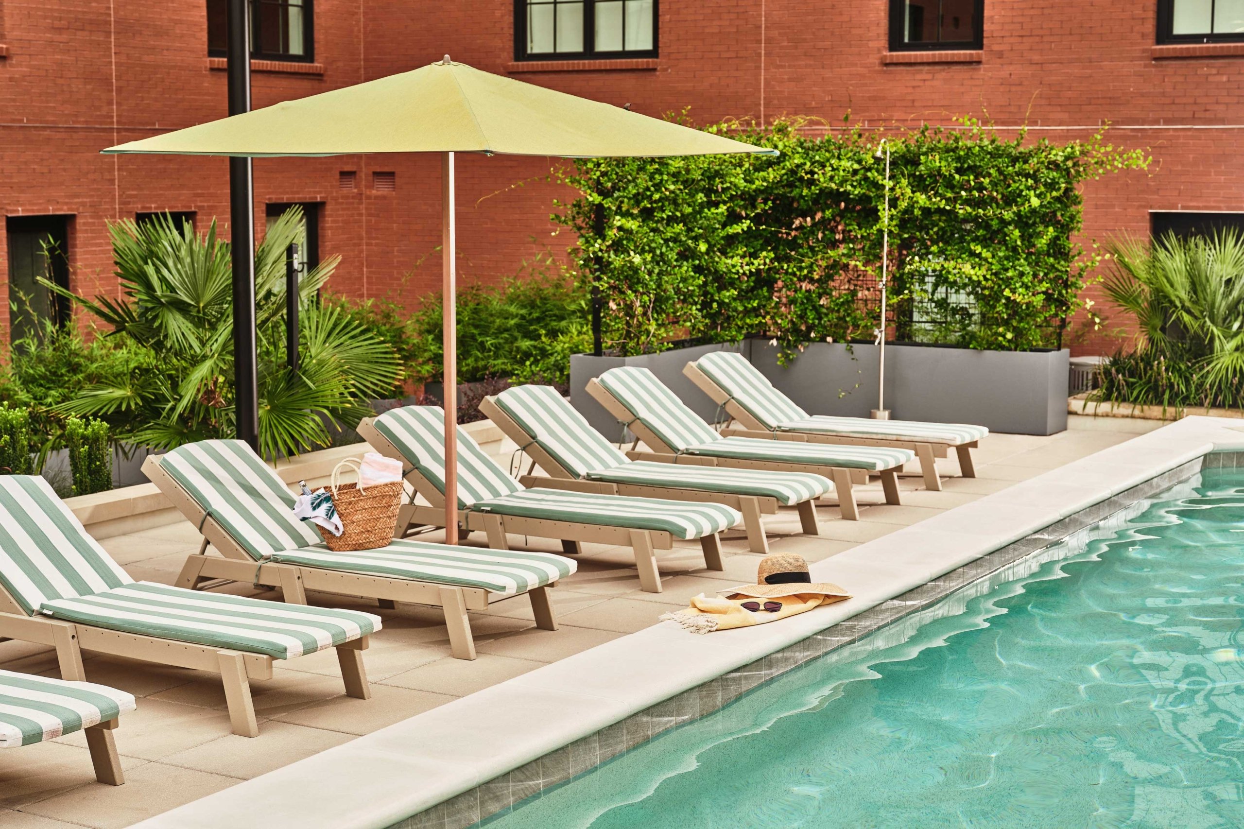 View of pool and lounge chairs with umbrella